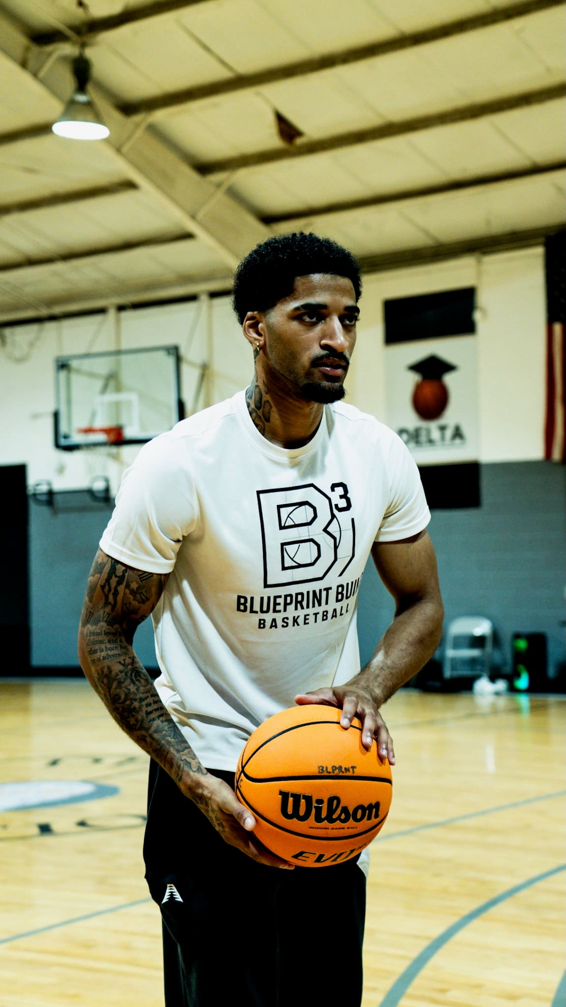 Josiah Bunton, founder of Blueprint Built Basketball, holding a basketball on the court